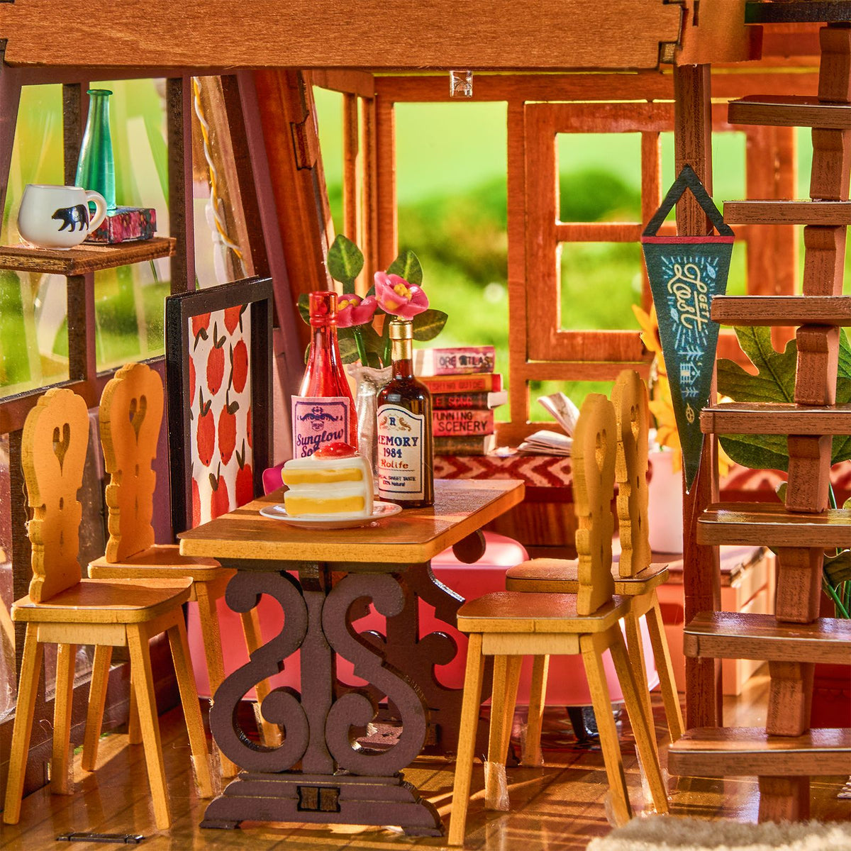 De knusse eethoek met houten stoelen en gedekte houten tafel in de Robotime A-Frame Cabin