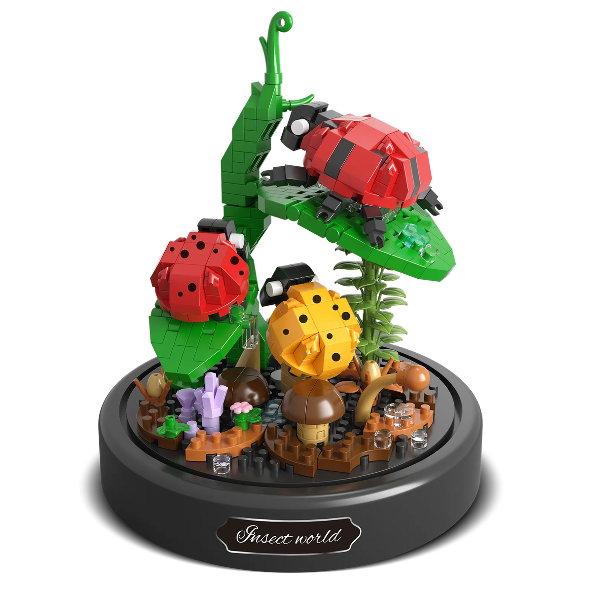 Productfoto van de Balody miniblocks twee rode en een geel lieveheersbeestje op een stengel met bladeren en paddestoeltjes op de grond, onder een stolp