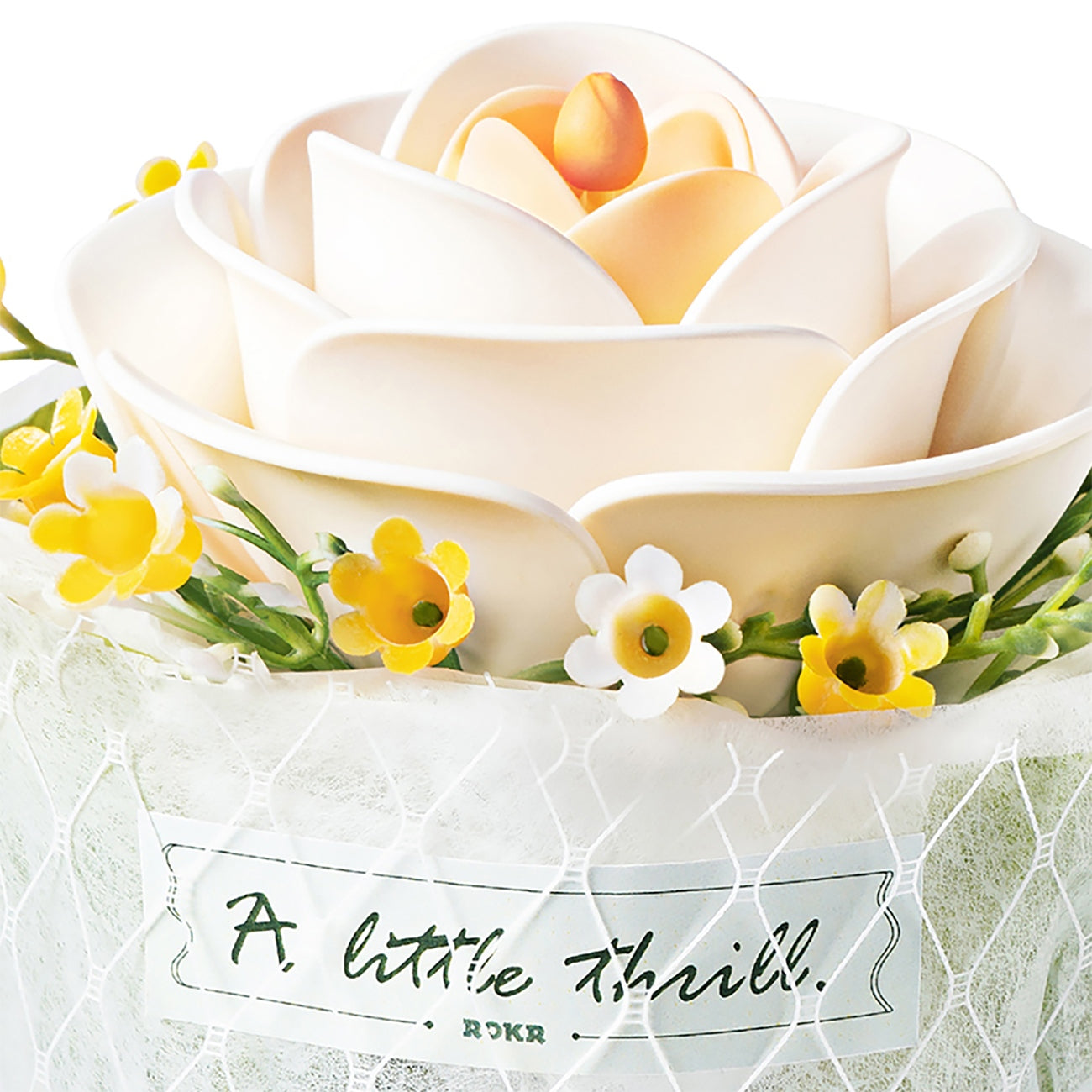 Close up van de witte bloem en stoffen wikkel met tekst van de Robotime Camellia