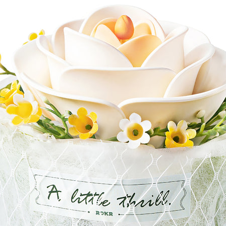 Close up van de witte bloem en stoffen wikkel met tekst van de Robotime Camellia