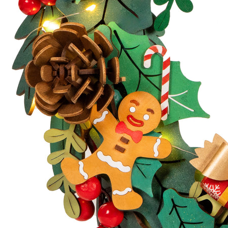 Details van het peperkoekenmannetje en dennenappel van de Robotime Christmas Wreath