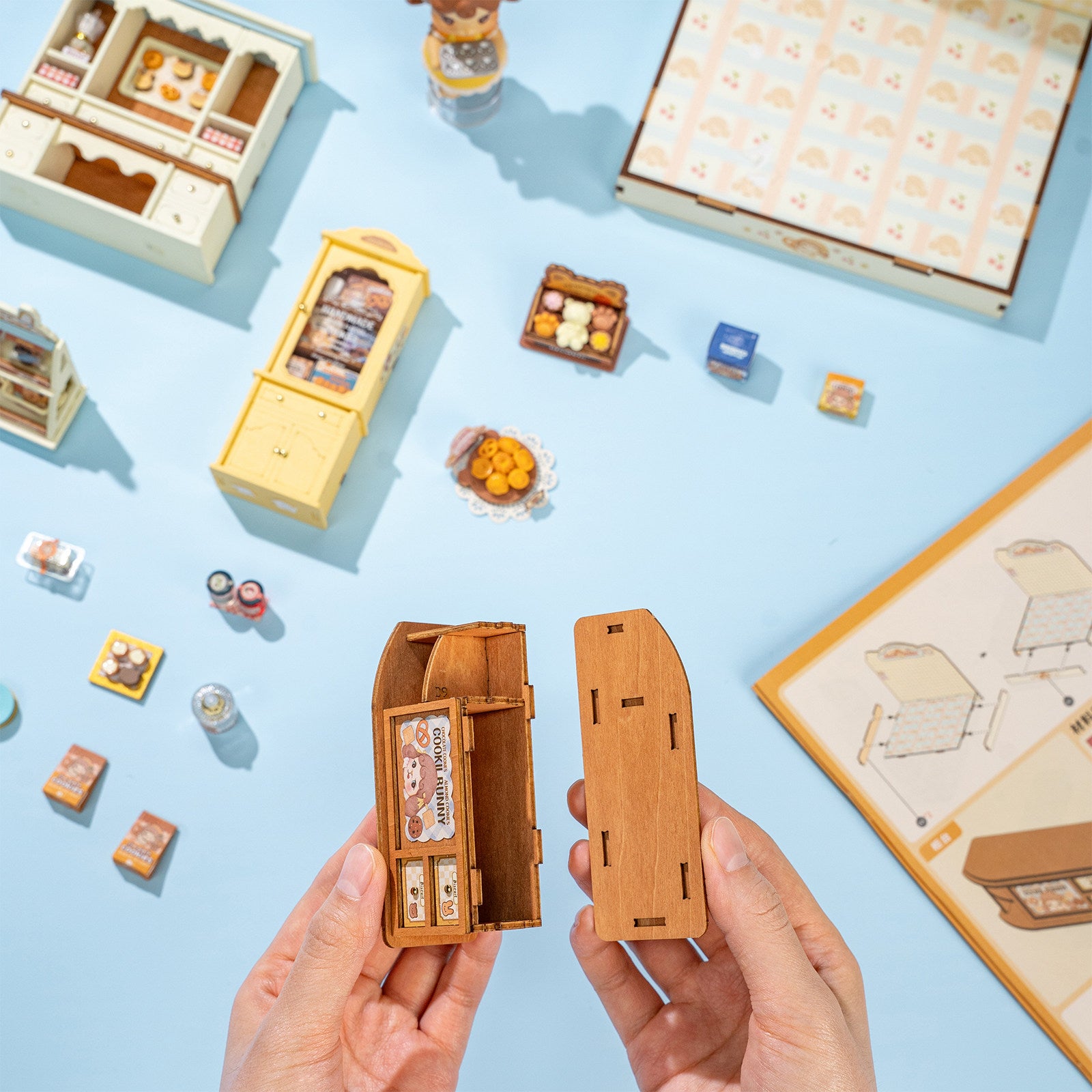 Een persoon bouwt de toonbank van de Robotime Cookii Bunny’s Cookie Shop