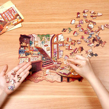 Een persoon is bezig de Robotime Cozy Winter Café legpuzzel te maken