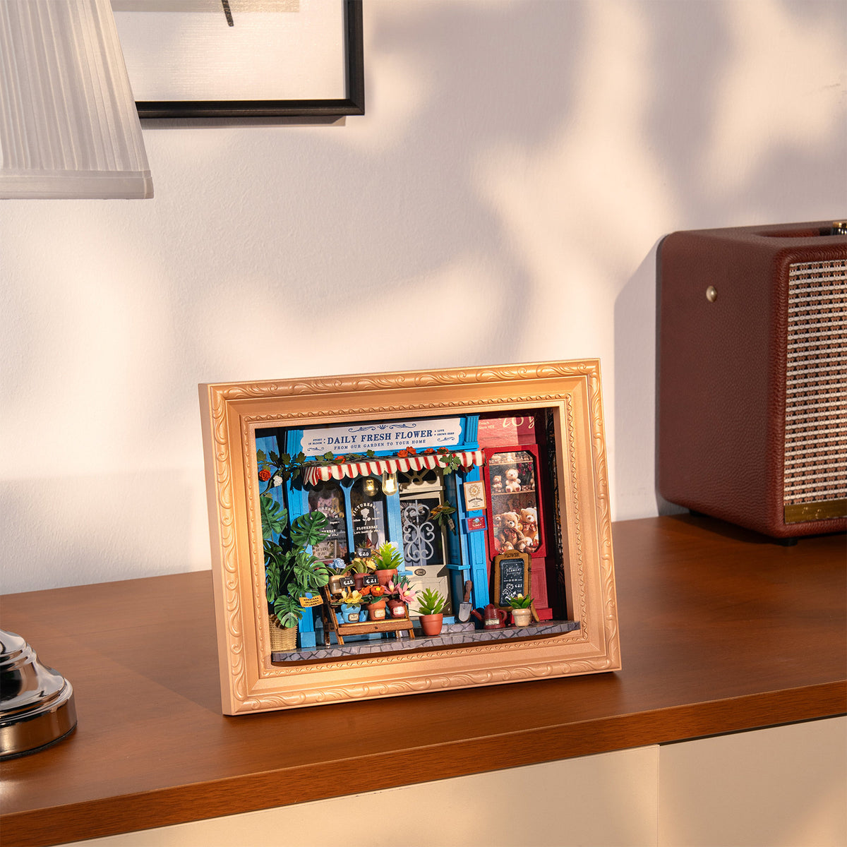 Sfeervolle presentatie van de Robotime Daily Fresh Flower, diorama in een lijst van een ouderwets winkeltje met bloemen en planten