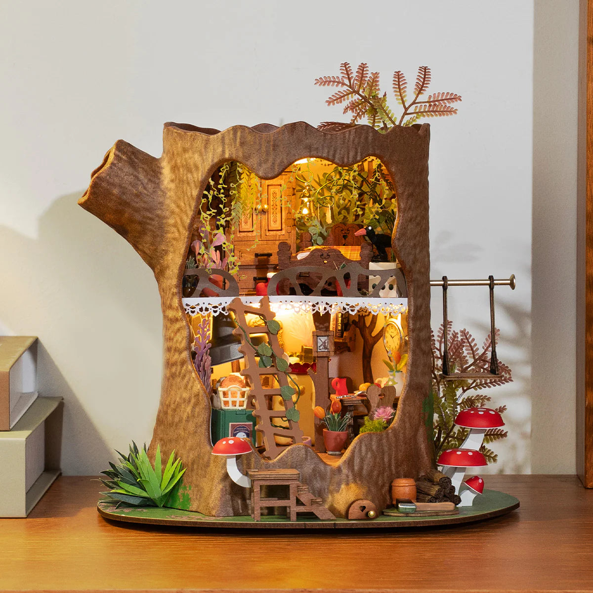 Sfeervolle presentatie van de Robotime Fairytale Tree House, bouwpakket van een miniatuurhuisje van twee verdiepingen in een holle boomstronk