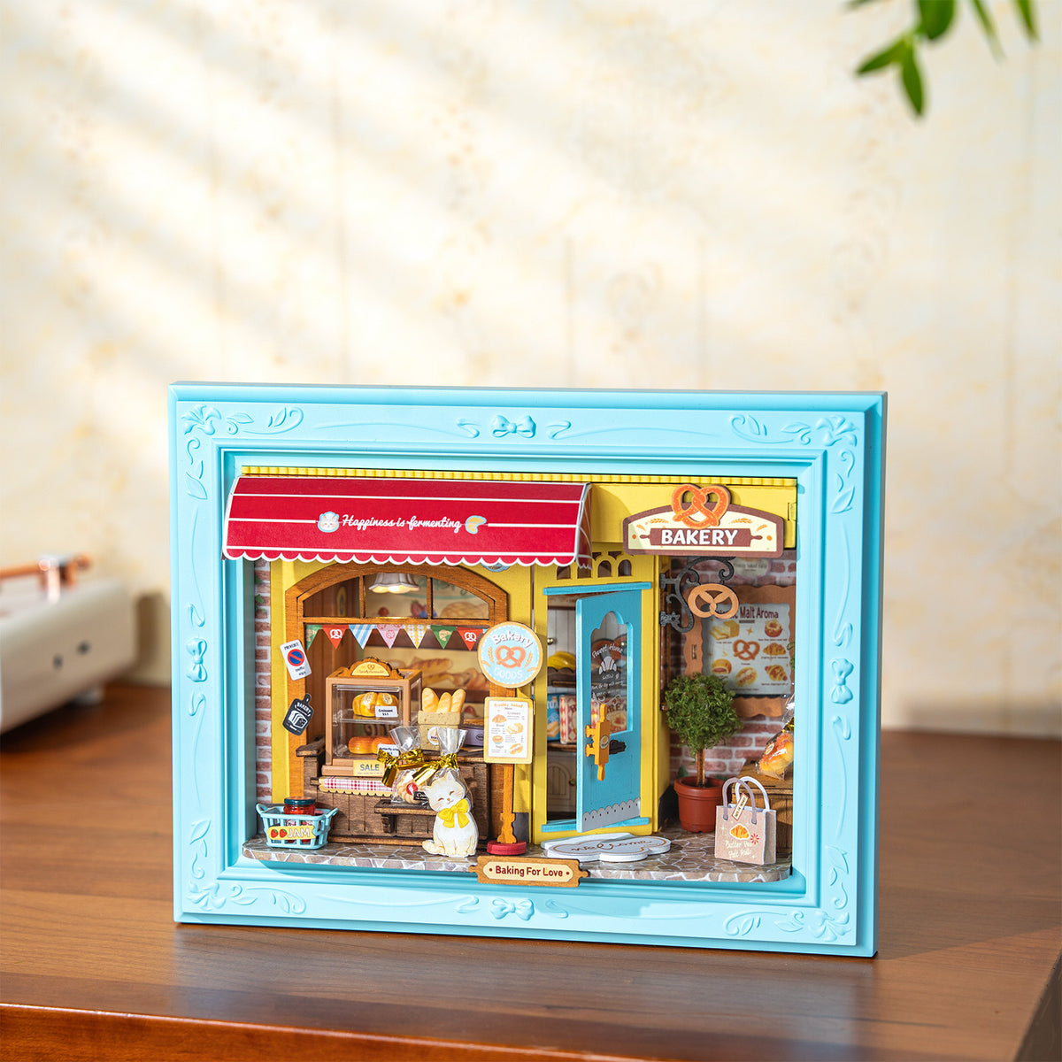 Sfeervolle presentatie van de Robotime Fluffy Cat Bakery, diorama in een lijst van een bakkerijtje met een kat