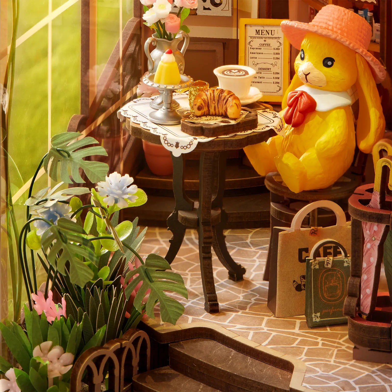 Een konijntje met een hoed zit aan een gedekte tafel op het terras van de Robotime Holiday Café