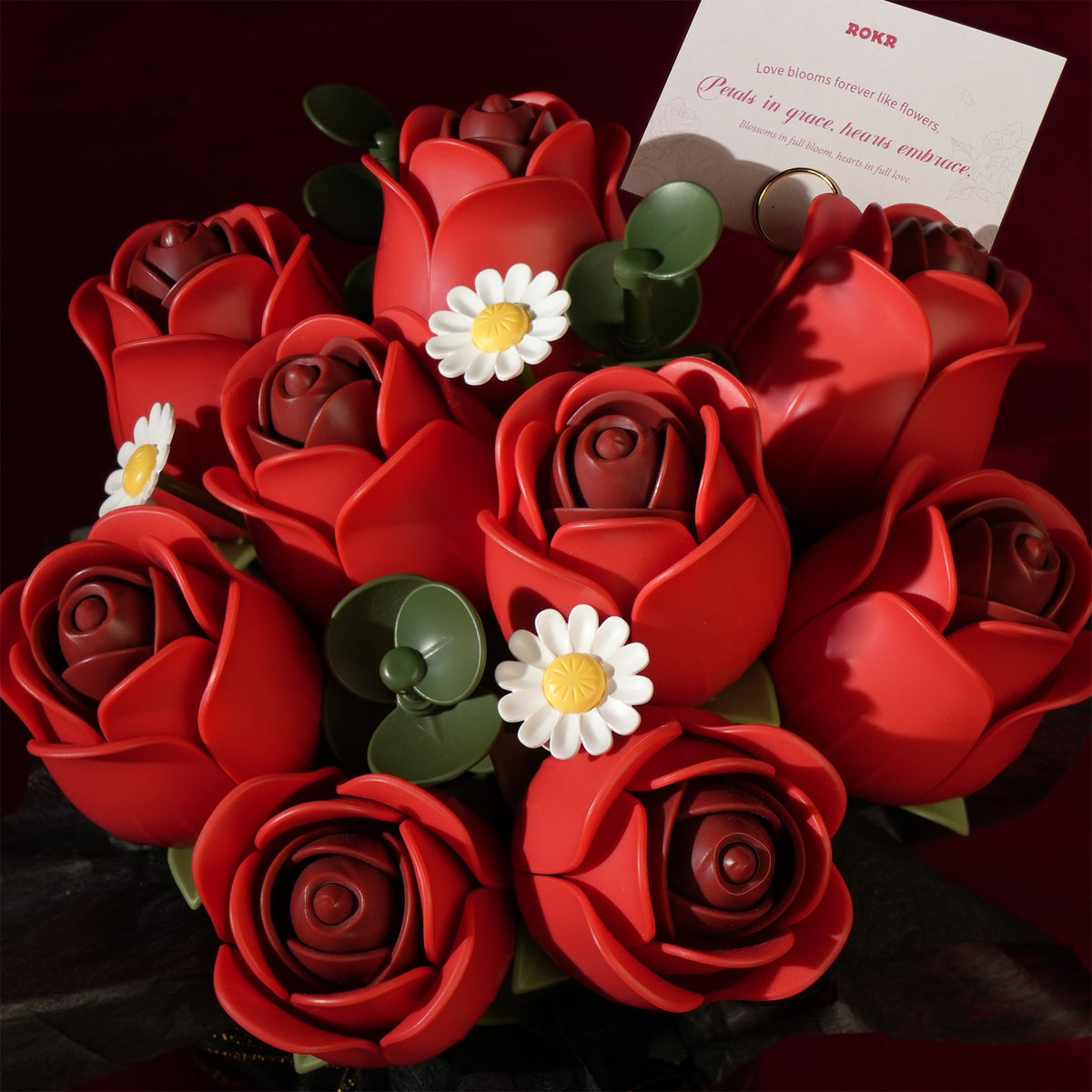 Bovenaanzicht van de negen rozen in de Robotime Red Rose Bouquet, kunststof bouwpakket van een boeket rode rozen en witte madeliefjes in een zwarte vaas met zwart lintje erom