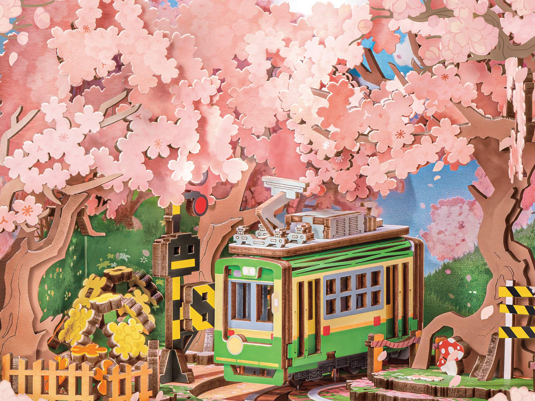 Details van de sakura bomen en de groene tram op de spoorwegovergang in de Robotime Sakura Dreamy Tour