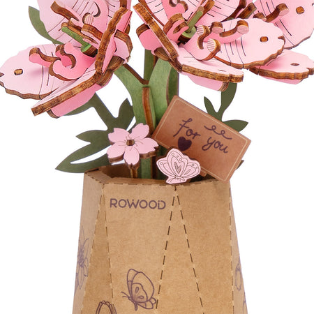 Details van de bloemetjes en vaasje met klein bordje van de Robotime Sakura
