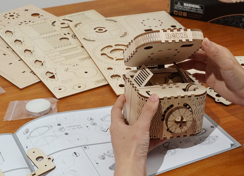 Sfeerfoto van de voltooide Robotime Treasure Box met doos en verpakkingsinhoud in de achtergrond
