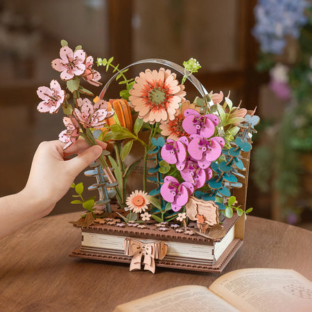 Een persoon zet de laatste bloem in de Robotime Wooden Blooming Book